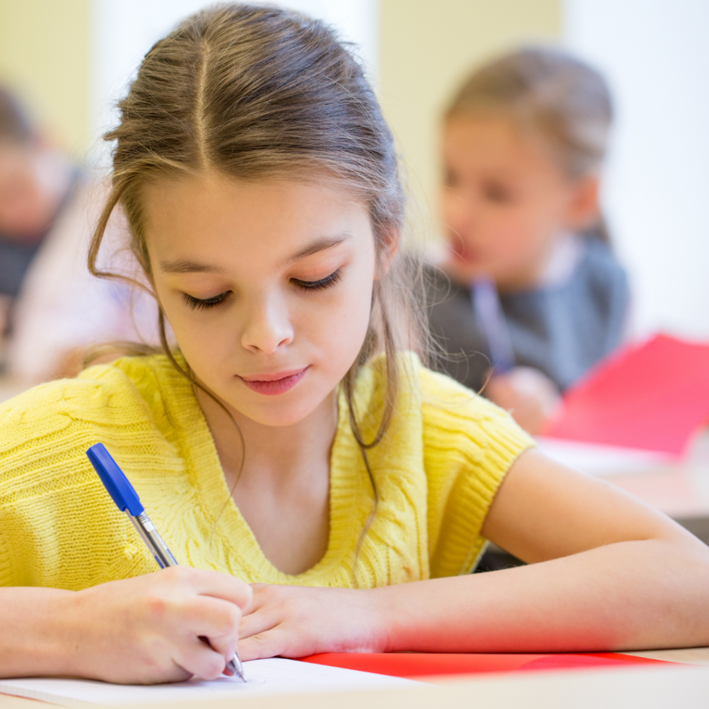 Four Tips for Success With EIW's Homeschool Writing Curriculum 5 a girl writing with a mechanical pencil in a notebook